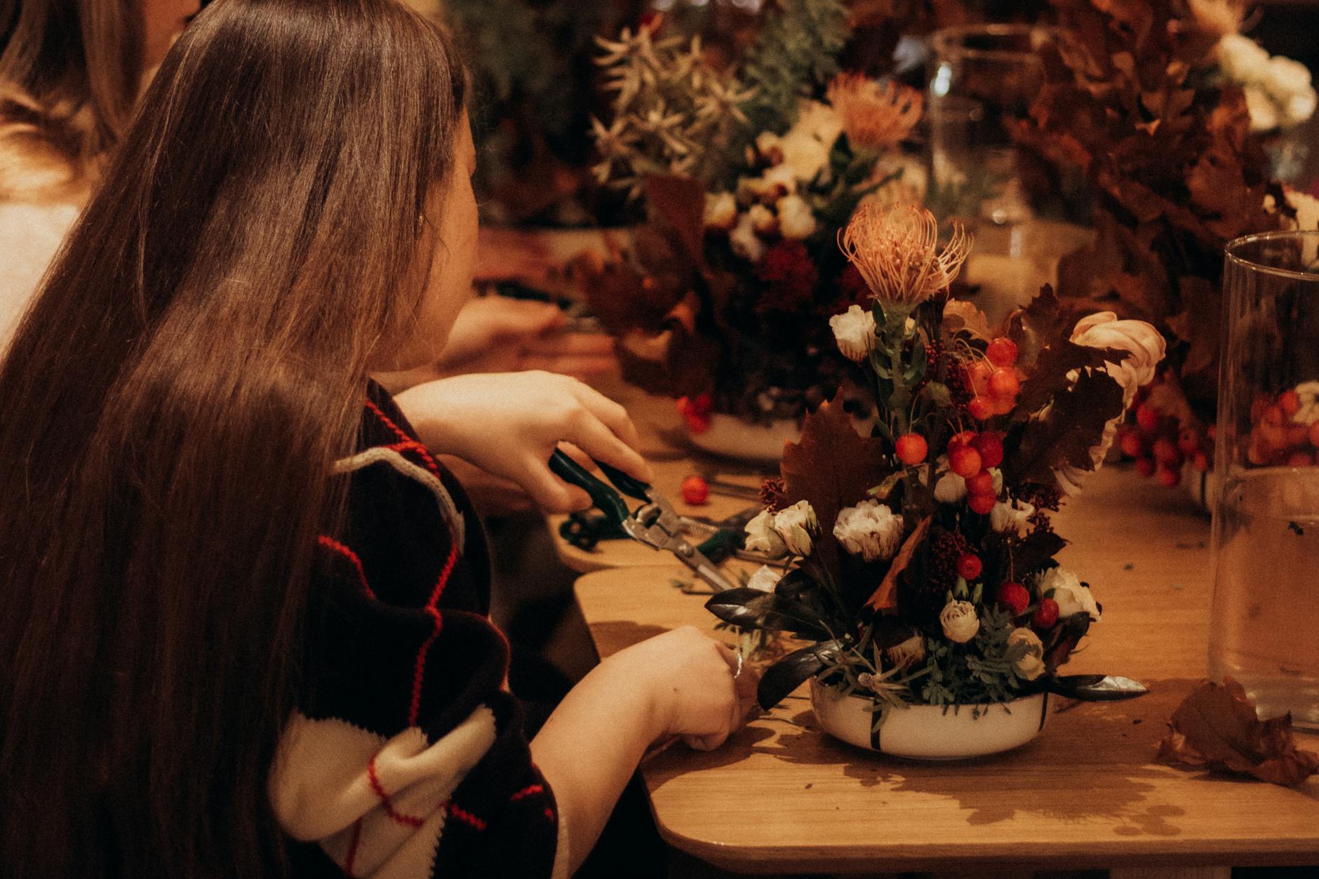 Floristin gestaltet ein liebevolles Blumenarrangement im Atelier